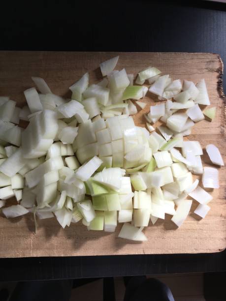 istock Chopped onion on a wooden cutting board 1298568921