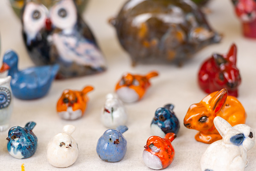 Figures of birds and animals. Colorful clay figures on the counter.