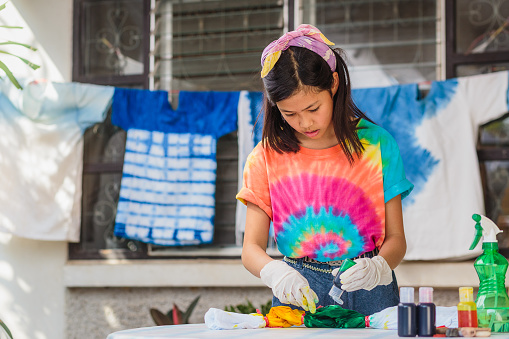 Young Asian girl enjoy making tie dye clothes at home