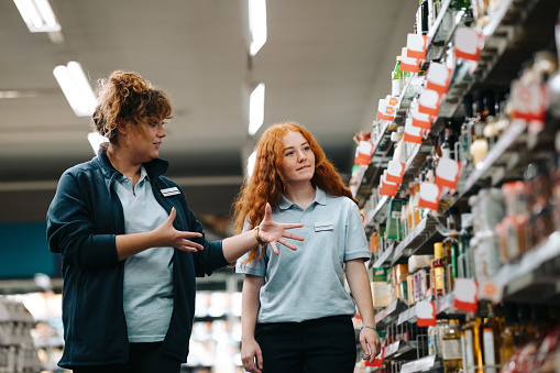 Gerente de supermercado dando capacitación a un empleado en prácticas photo