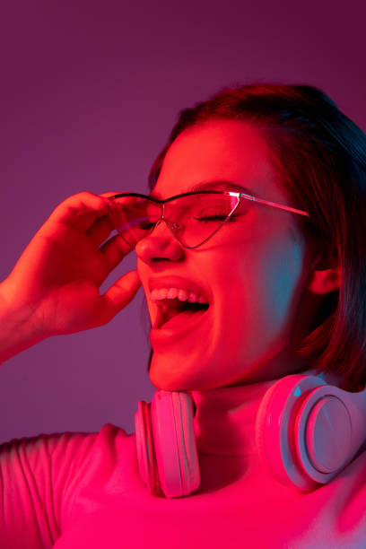istock Caucasian woman's portrait isolated on pink studio background in multicolored neon light 1298572412