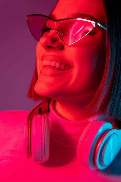 istock Caucasian woman's portrait isolated on pink studio background in multicolored neon light 1298572413