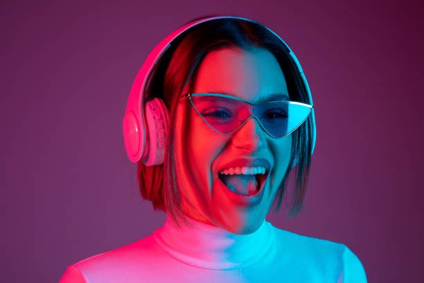 istock Caucasian woman's portrait isolated on pink studio background in multicolored neon light 1298572415