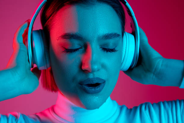 istock Caucasian woman's portrait isolated on pink studio background in multicolored neon light 1298572442