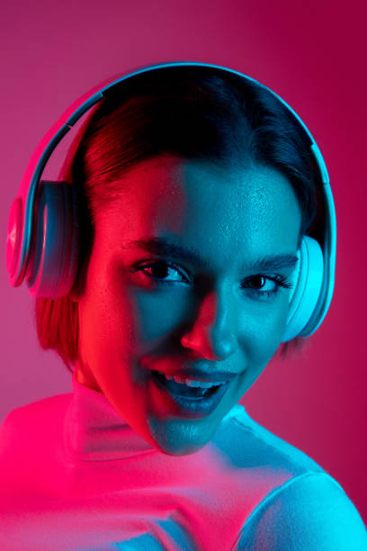 istock Caucasian woman's portrait isolated on pink studio background in multicolored neon light 1298572456