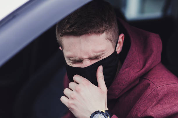 istock man the driver in the mask coughs 1298573014