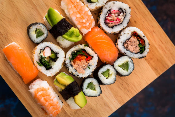 frische sushi-auswahl auf holzbrett - seafood prepared shrimp prawn avocado stock-fotos und bilder