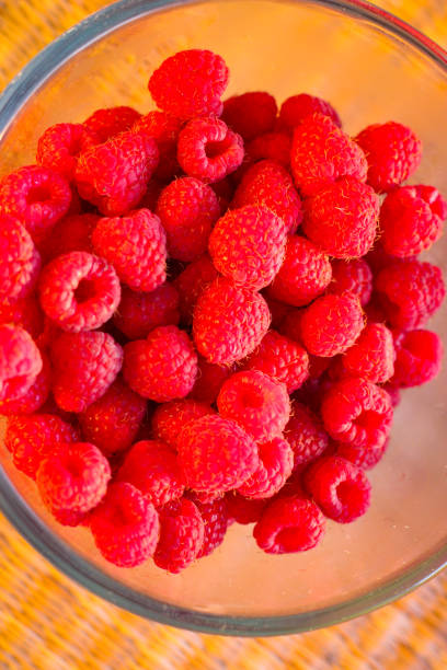 istock Red ripe and juicy raspberry in a glass bowl 1298576152