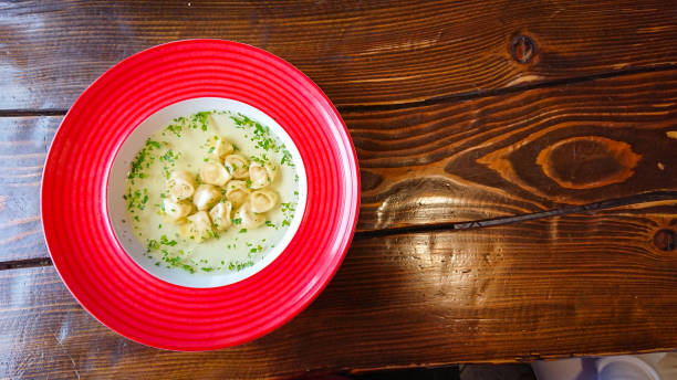 istock Red plate with broth and dumplings on the table 1298576673