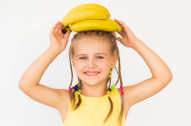 kid girl with fine banana isolated on white - facial expression isolated lifestyles exoticism imagens e fotografias de stock