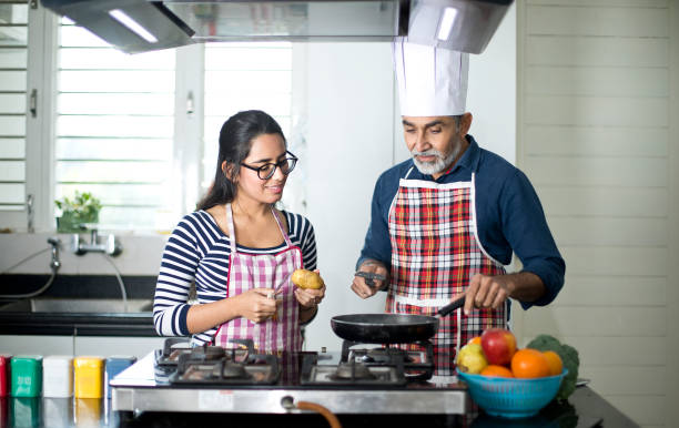 istock Father giving culinary lessons to daughter at kitchen 1298578877