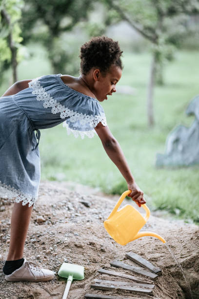 istock Young girl playing in back yard with watering bucket 1298579620