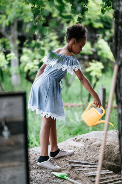 istock Young girl playing in back yard with watering bucket 1298579682