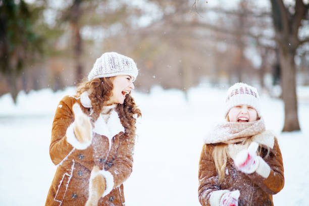 istock happy modern mother and child shaking off snow from mittens 1298582302