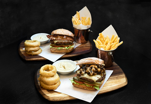 Two burgers and chips with onion rings