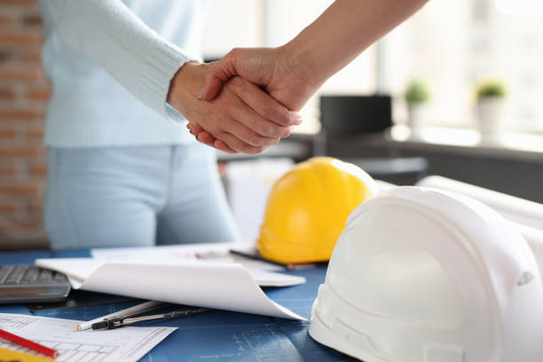 istock Over construction sketches, designer and client shake hands with each other 1298588369