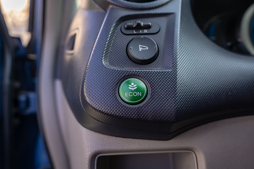eco button in a hybrid car, switching vehicle to eco mode to save the environment, electric car