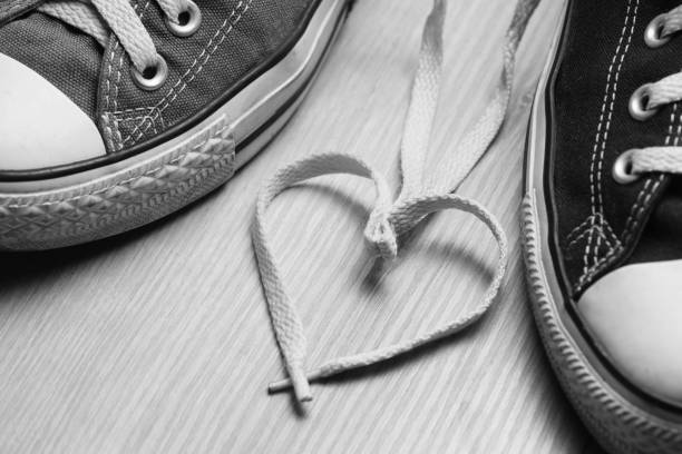 Heart-shaped laces between men's and women's sneakers.