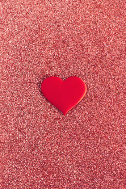 istock Red heart on a red sparkle background. Minimal concept for Valentine day. 1298593197