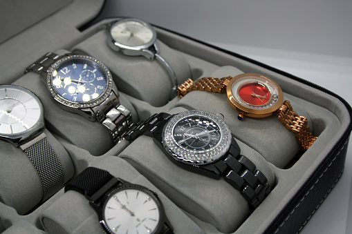 A variety of women's watches in a storage box. Background for text.