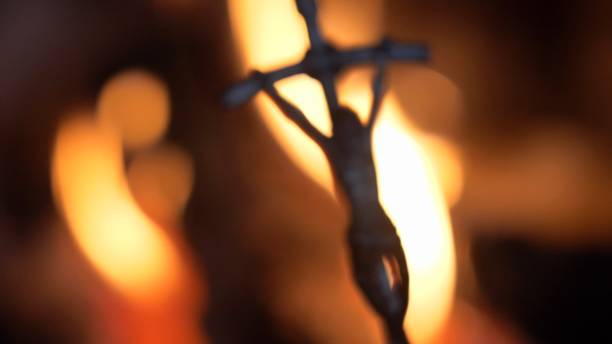 Blurred Crucifix Silhouette on Fire Flames Dark Background Slow Motion Blurred Crucifix Silhouette on Fire Flames Dark Background Slow Motion exorcism stock pictures, royalty-free photos & images