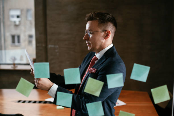 istock Businessman in conference room use sticky notes on glass wall. 1298602897