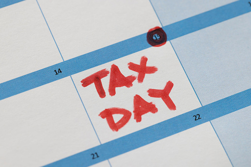 Date of tax filing is marked in red on calendar. Tax return concept