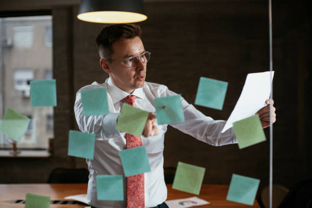 istock Businessman in conference room use sticky notes on glass wall. 1298605717