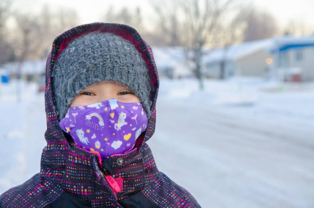 istock Girl with mask waiting her school bus 1298605768