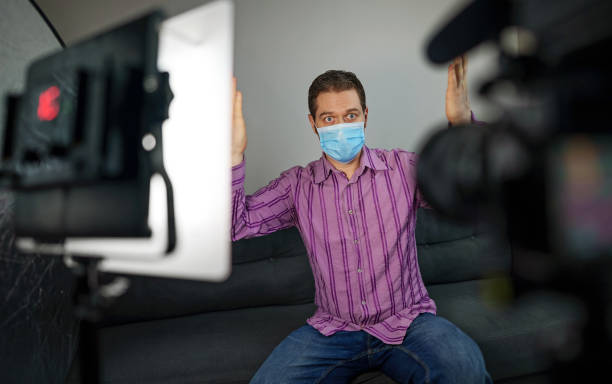 istock Man in medical mask talking about coronavirus. Vlog concept. 1298605787