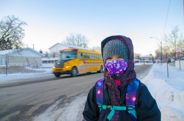 Girl with mask waiting her school bus
