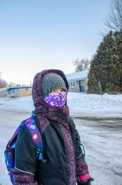 istock Girl with mask waiting her school bus 1298606070