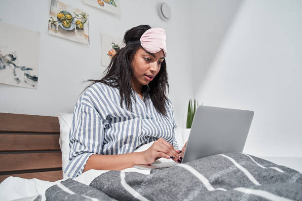istock Woman drinking coffee and looking at laptop at home 1298606340