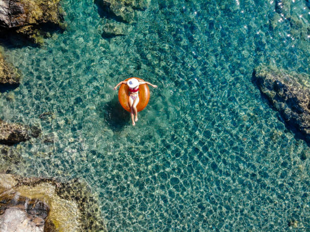 Beautiful woman relaxing on inflatable mattress in sea. Beautiful woman relaxing on inflatable mattress in sea. bodrum stock pictures, royalty-free photos & images