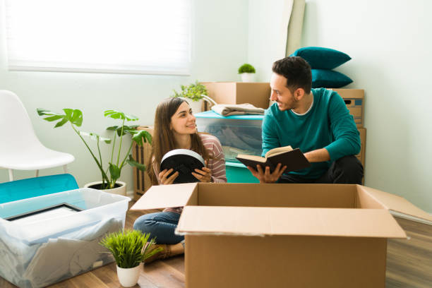 istock Latin man and woman unpacking cardboard boxes 1298607926