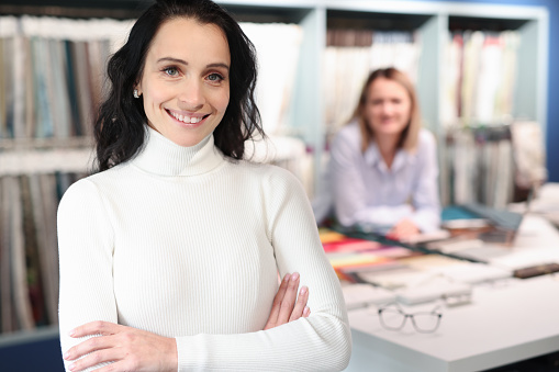 Portrait of smiling female consultant in tissue salon. Customer service rules concept