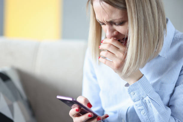 istock Woman cries and looks at smartphone screen 1298608418
