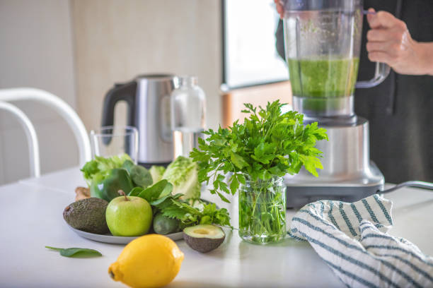 istock Woman preparing green smoothie in the kitchen 1298610773