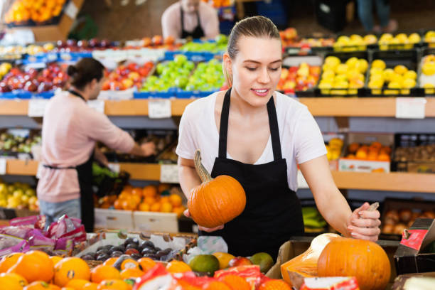 istock Young woman with pumpkin in hands and man  on background 1298610814