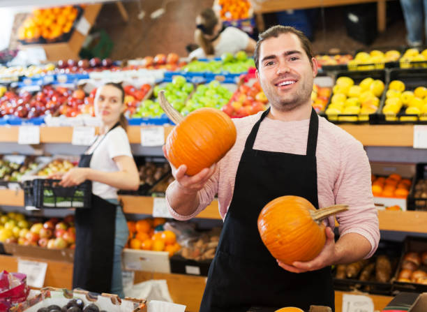 istock Seller with pumpkin in supermarket 1298610824
