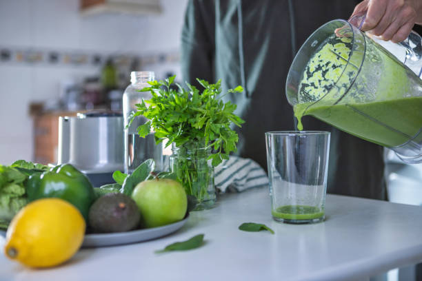 istock Woman preparing green smoothie in the kitchen 1298611097
