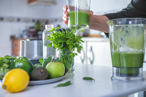 istock Woman preparing green smoothie in the kitchen 1298611099