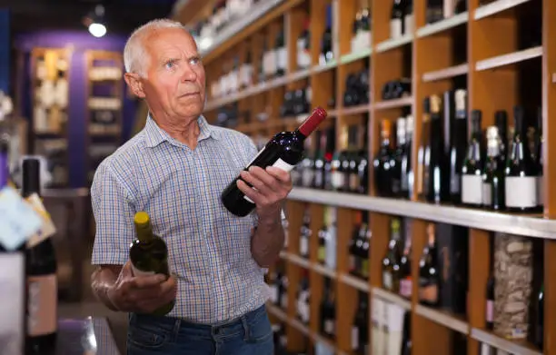 Elderly man visiting winehouse in search of bottle of good wine