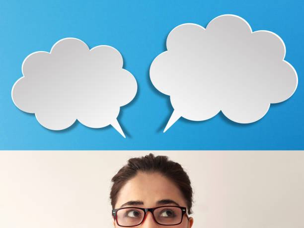 istock Business woman with empty speech bubbles on blue background 1298612561