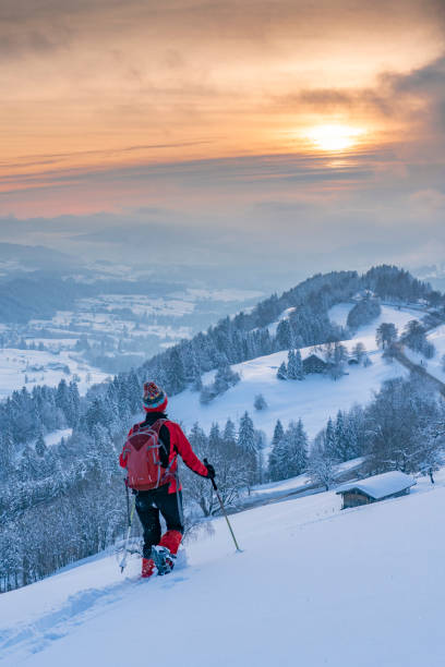 nice woman snowshoeing in the Bavarian Alps nice active senior woman snowshoeing in the Allgaeu Alps near Oberstaufen with view into the Bregenzerwald, Vorarlberg, Austria 490 stock pictures, royalty-free photos & images