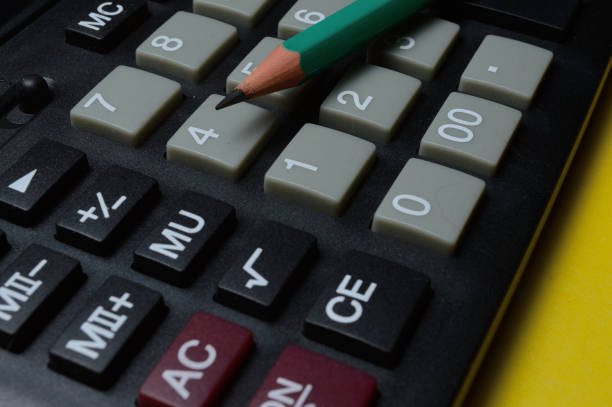 istock calculator and pencil lie on a yellow background. close-up. 1298614168