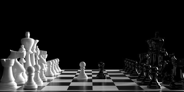 Business strategy, teamwork and competition concept. 3d rendered chess pieces standing face to face on chess board. 2 pawn standing in font of trams. First move of each player. Dark atmosphere and large copy space.