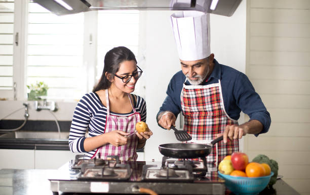 istock Father giving culinary lessons to daughter at kitchen 1298615327