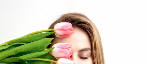 istock Young woman with pink tulips 1298616089