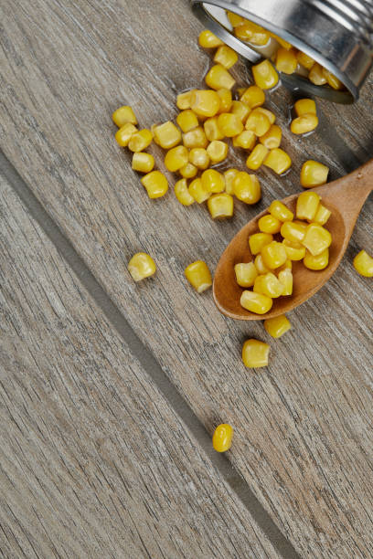 istock A can of boiled sweet corn on a wooden table with a spoon 1298616453